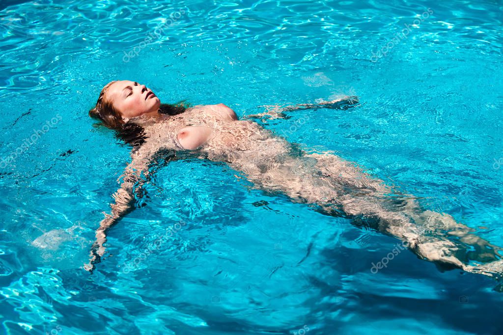 Junge nackte Frau genießen Sie das Schwimmen im pool.