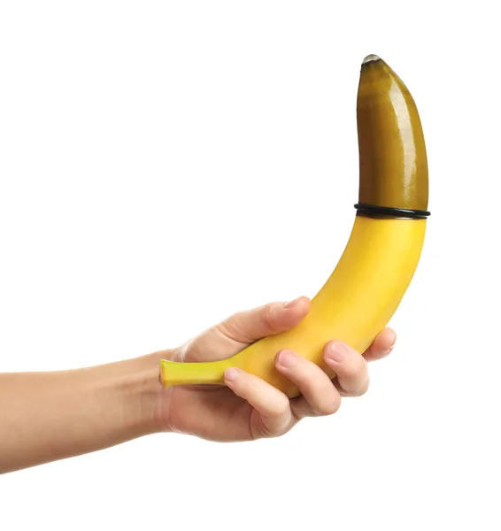Жінка тримає банан з презервативом — стокове фото