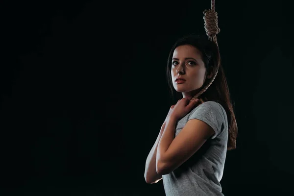 Depresso giovane donna guardando lontano mentre andando a suicidarsi impiccandosi isolato su nero — Foto stock
