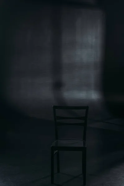 Стул на темном фоне с освещением, концепция предотвращения самоубийства — стоковое фото