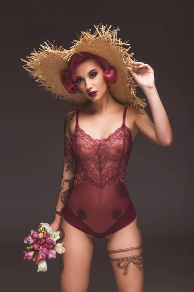 Sexy tatoué pin up fille avec des fleurs infront de fond gris — Photo de stock