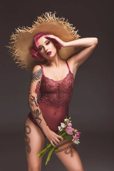 Sexy tätowierte Pin Up Mädchen mit Blumen vor grauem Hintergrund — Stockfoto